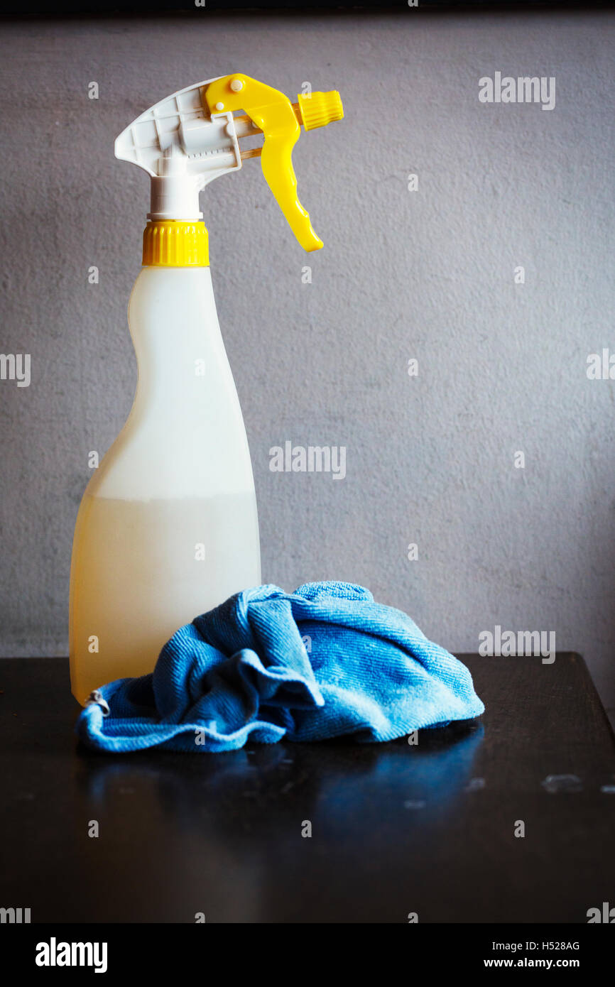 Spray bottle of kitchen cleaner and a blue cloth. Stock Photo