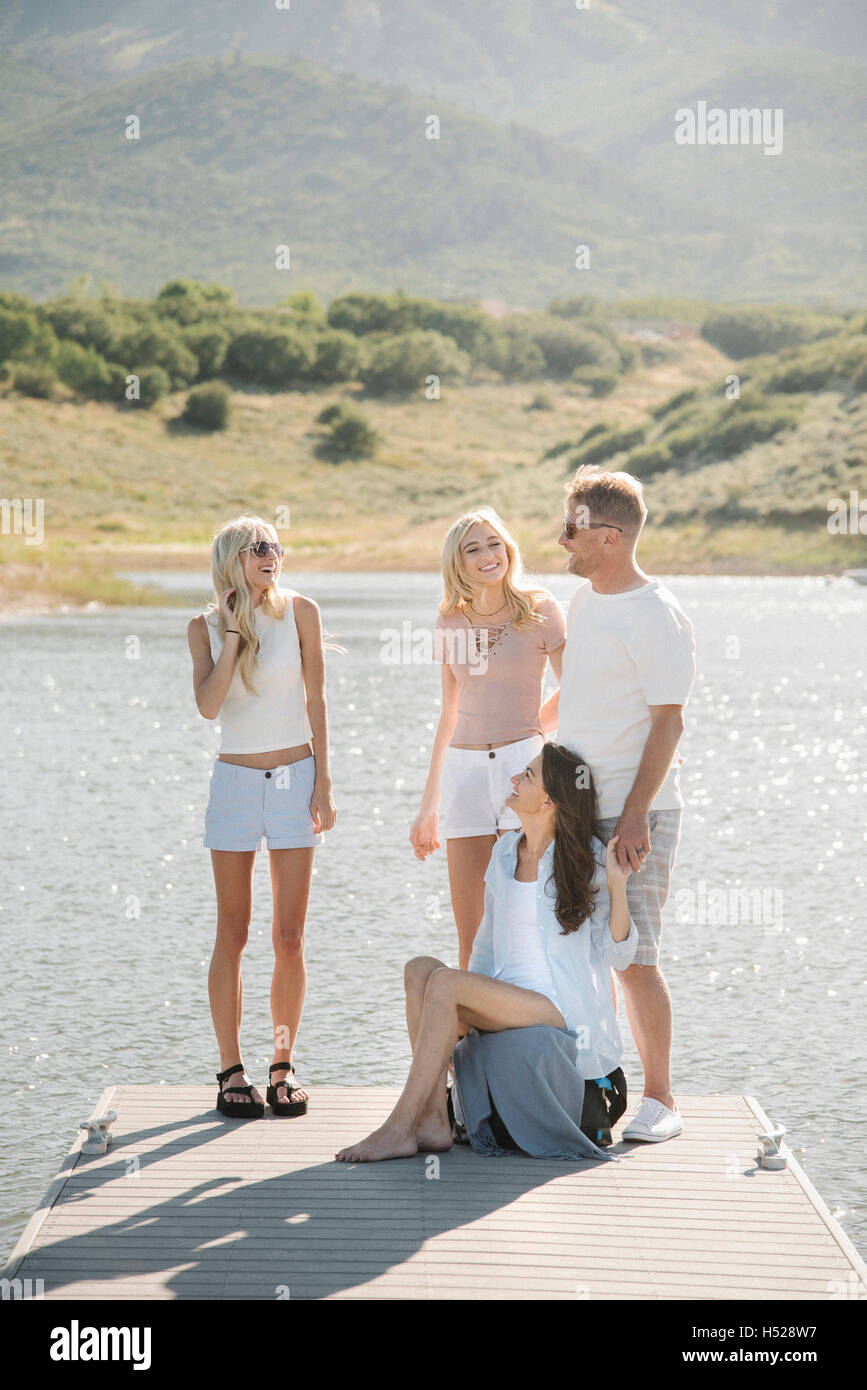 Man, woman and their two blond daughters on a jetty. Stock Photo