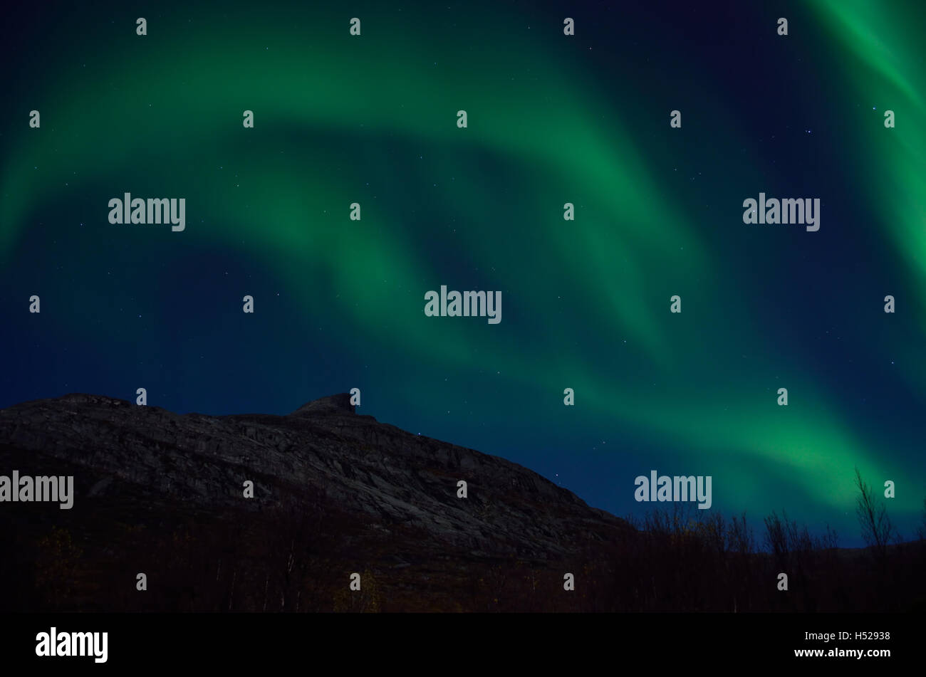 massive aurora borealis dancing on night sky over mountain in northern ...