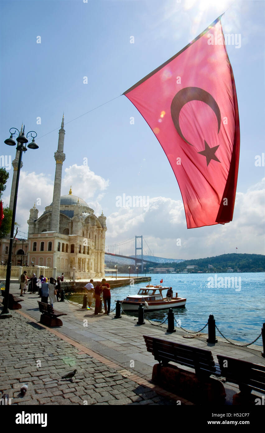 Turkish flag and Ortakoy Mosque with bridge over Bosporus Sea in background  in Istanbul, Turkey Stock Photo