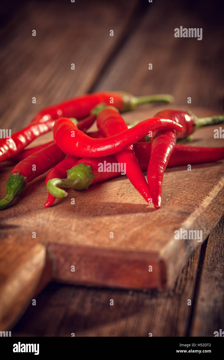 Red Chili Peppers on wooden cutting board Stock Photo - Alamy