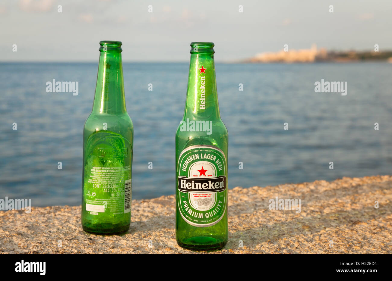 Heineken beer bottles sitting on the seawall of The Malecón (Avenida de Maceo) in Central Havana, Cuba. Stock Photo