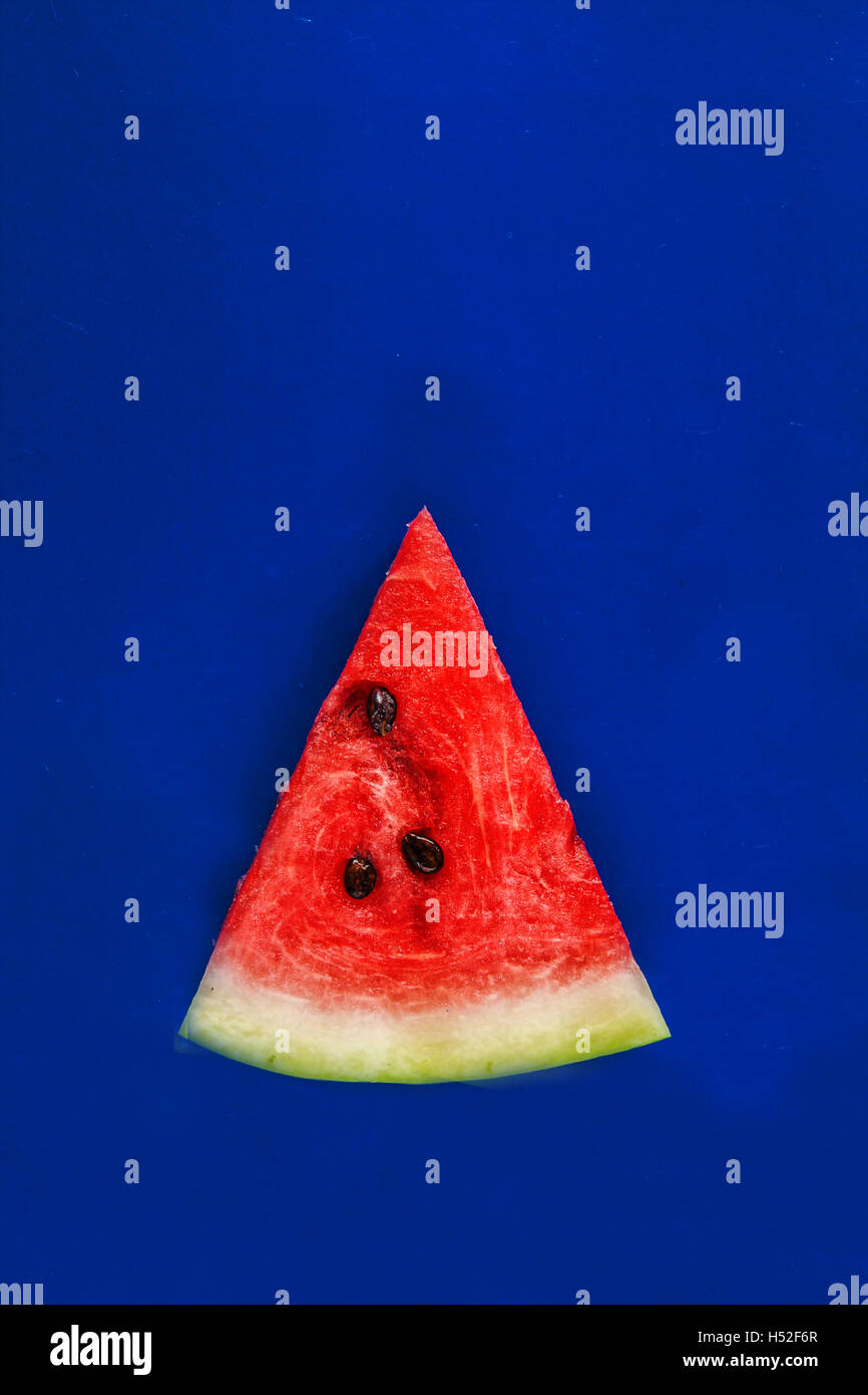 slice of watermelon on a blue background Stock Photo - Alamy