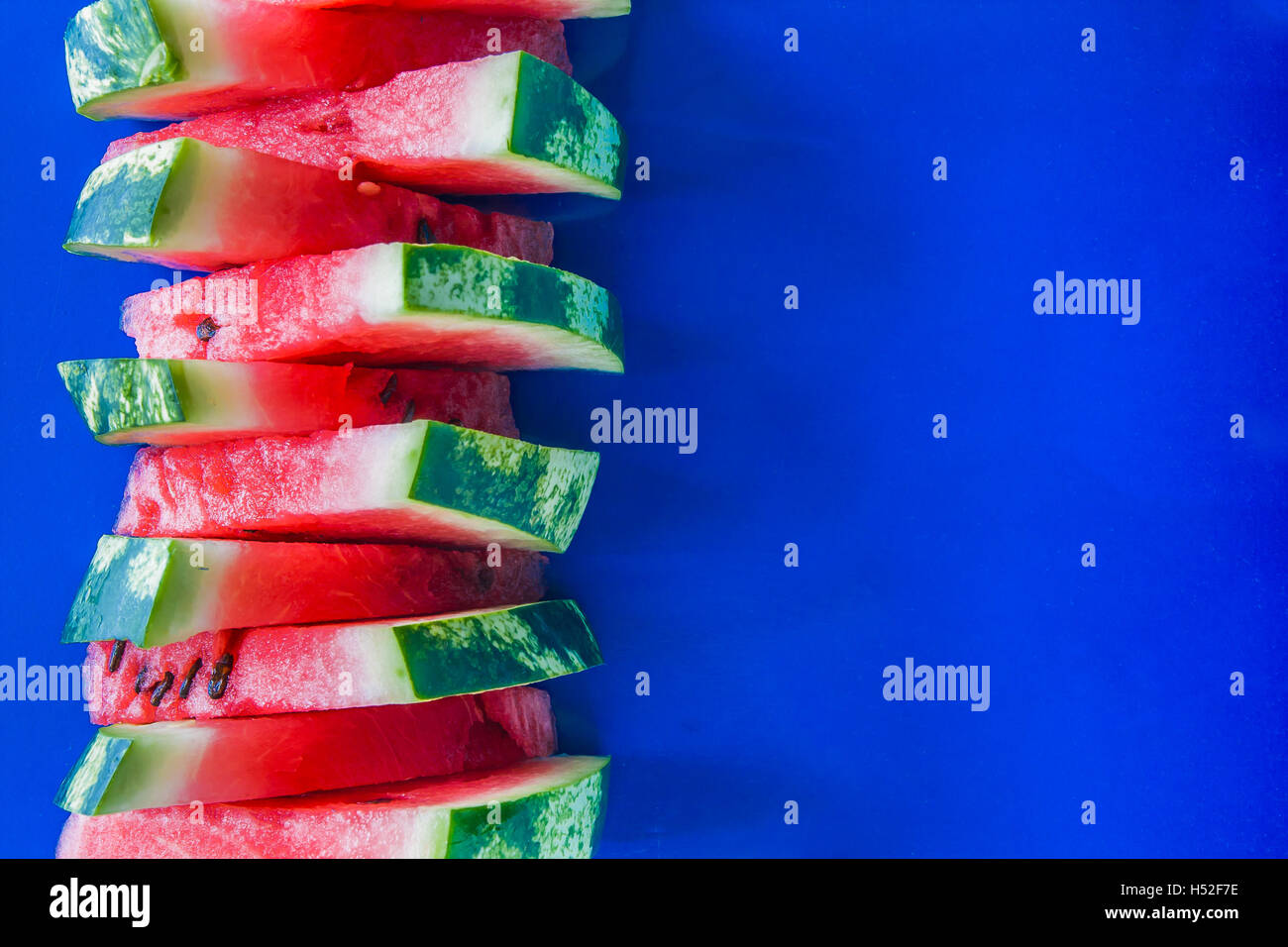 Tower of slices of watermelon on a blue background Stock Photo - Alamy