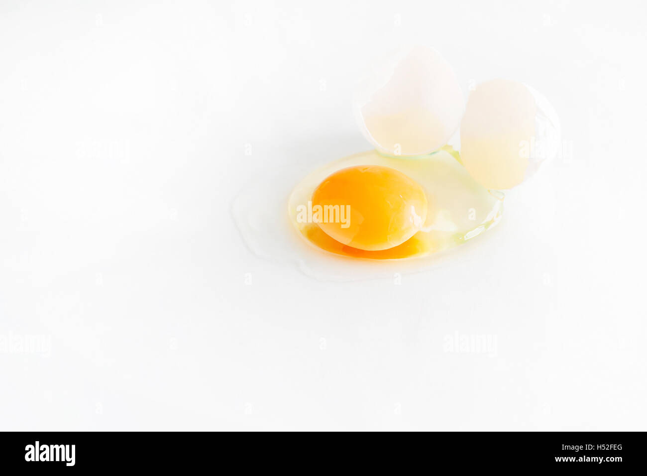 white egg is broken and leaked on a white background Stock Photo - Alamy