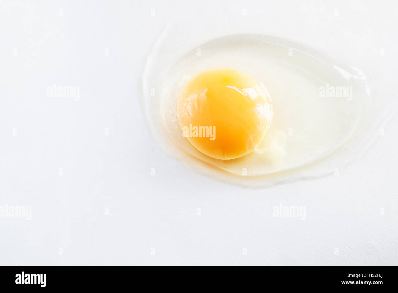 white egg is broken and leaked on a white background Stock Photo - Alamy