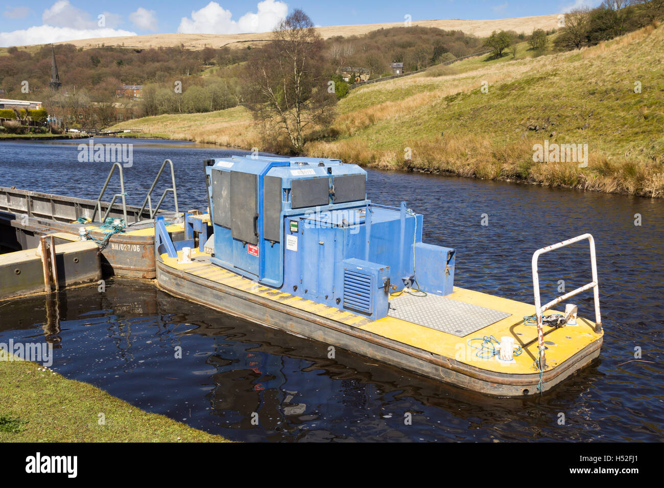 Canal maintenance boat moored on the Rochdale canal in the village of Walsden near the