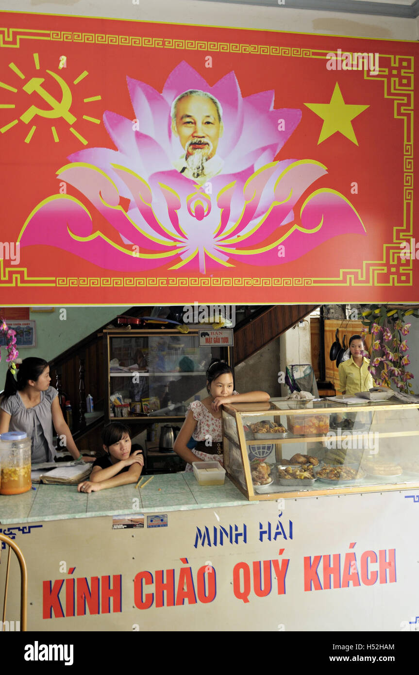 Four waitresses in a restaurant of Yen Minh with a portrait of Ho Chi Minh, Ha Giang province, North Vietnam Stock Photo