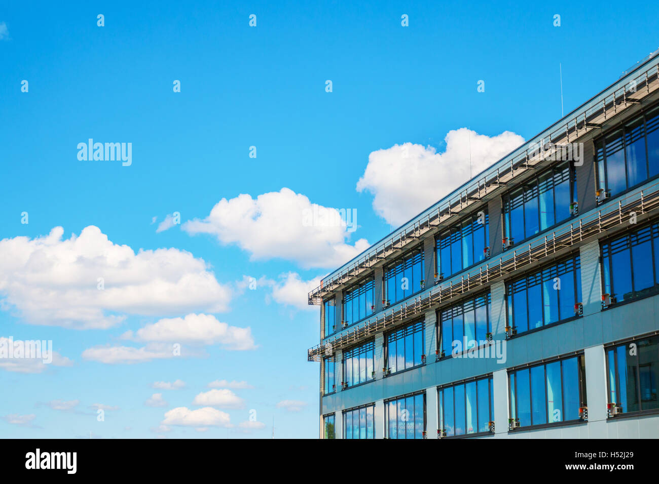 Modern office building against blue cloudy sky Stock Photo - Alamy