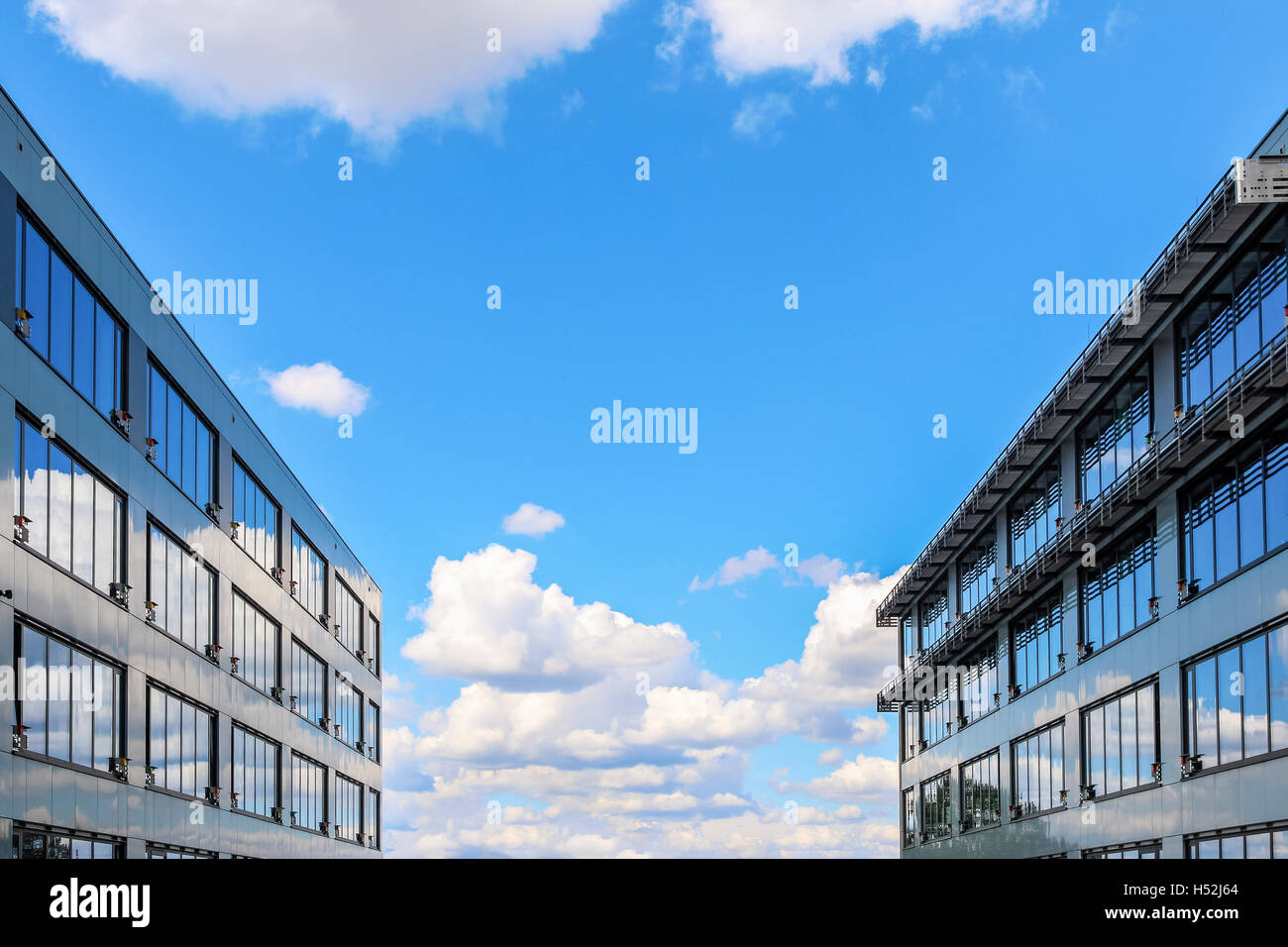 Modern office building against blue cloudy sky Stock Photo - Alamy
