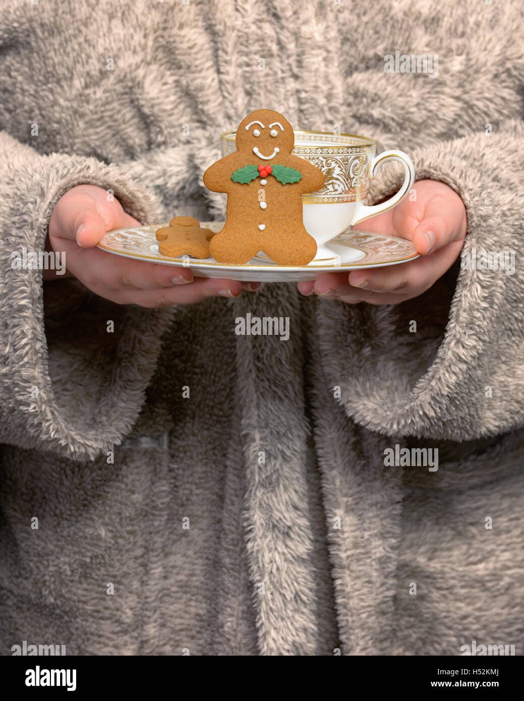 Young woman wearing robe holding gingerbread biscuits - warm vintage tone effect added Stock Photo