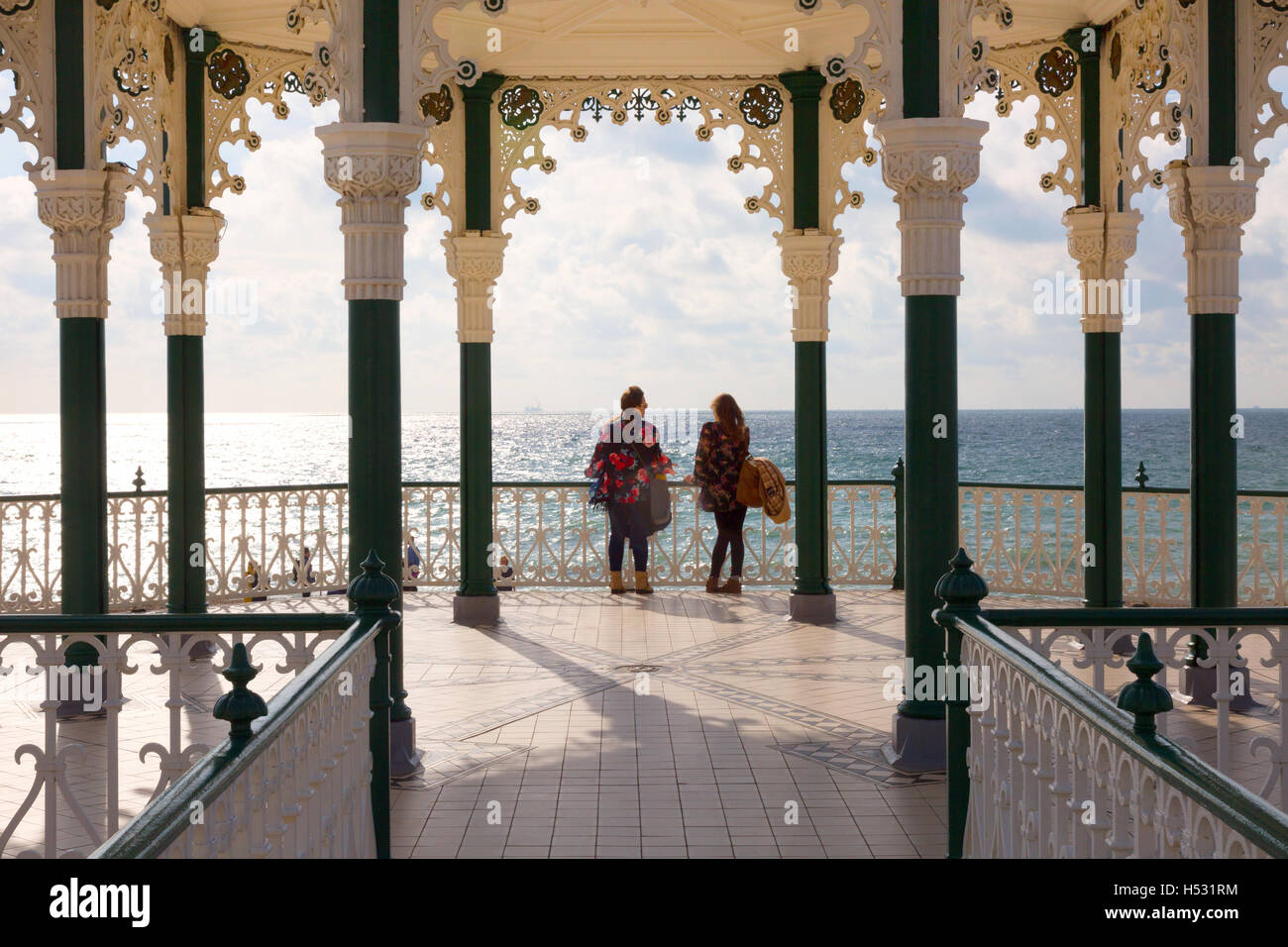 Two women standing in the bandstand, Brighton seafront, Brighton, Sussex England UK Stock Photo