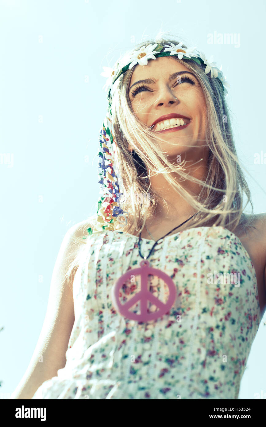 hippie girl with smile flowered dress and necklace with peace sign Stock Photo