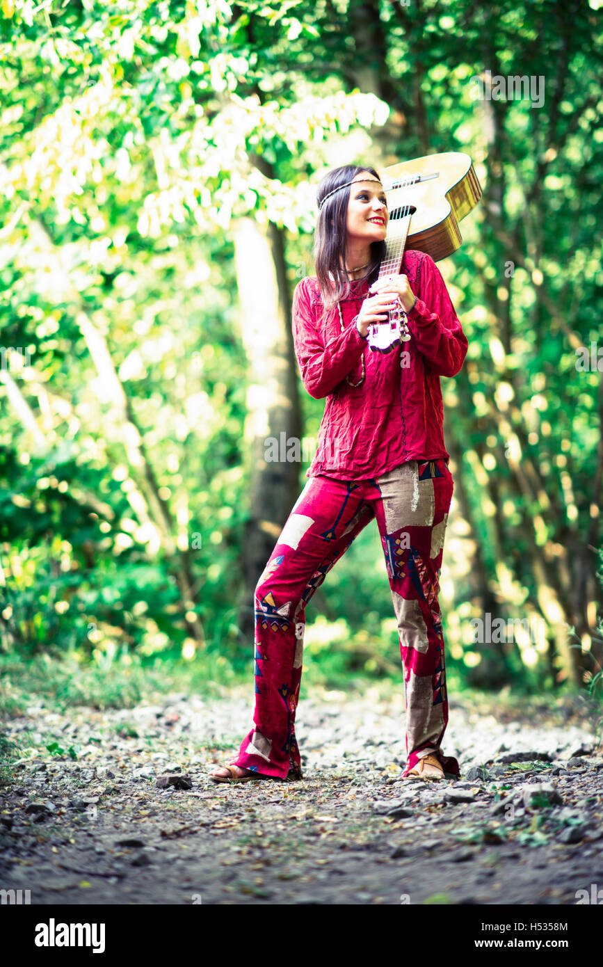Hippie girl with the guitar in the woods Stock Photo