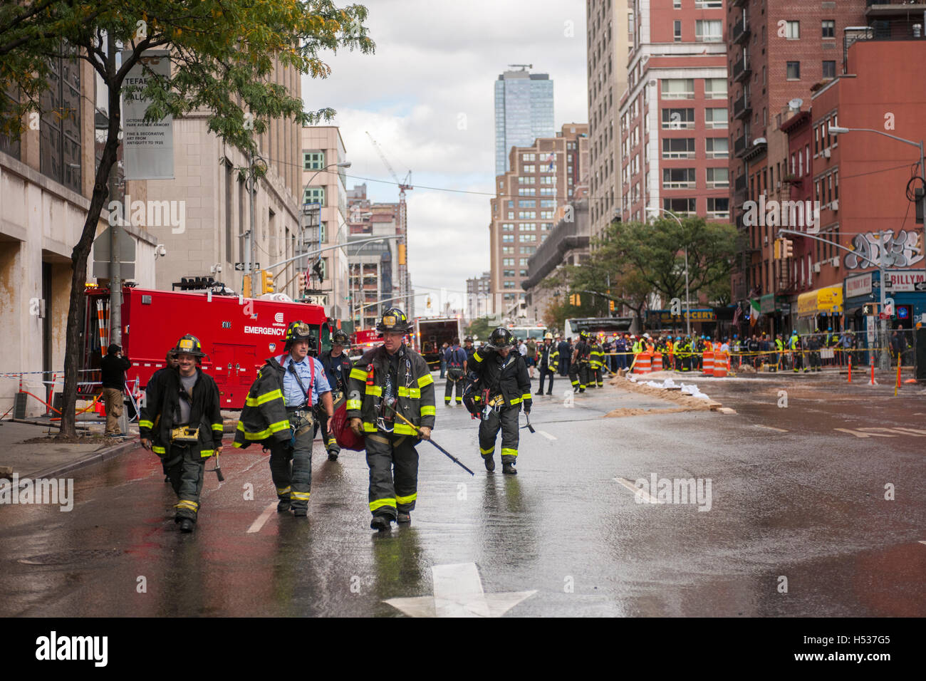 FDNY firefighters respond to a watermain break  in the Chelsea neighborhood of New York on Wednesday, October 12, 2016. The watermain break caused water to gush but it was mostly contained to the street safely running into storm drains. (© Richard B. Levine) Stock Photo