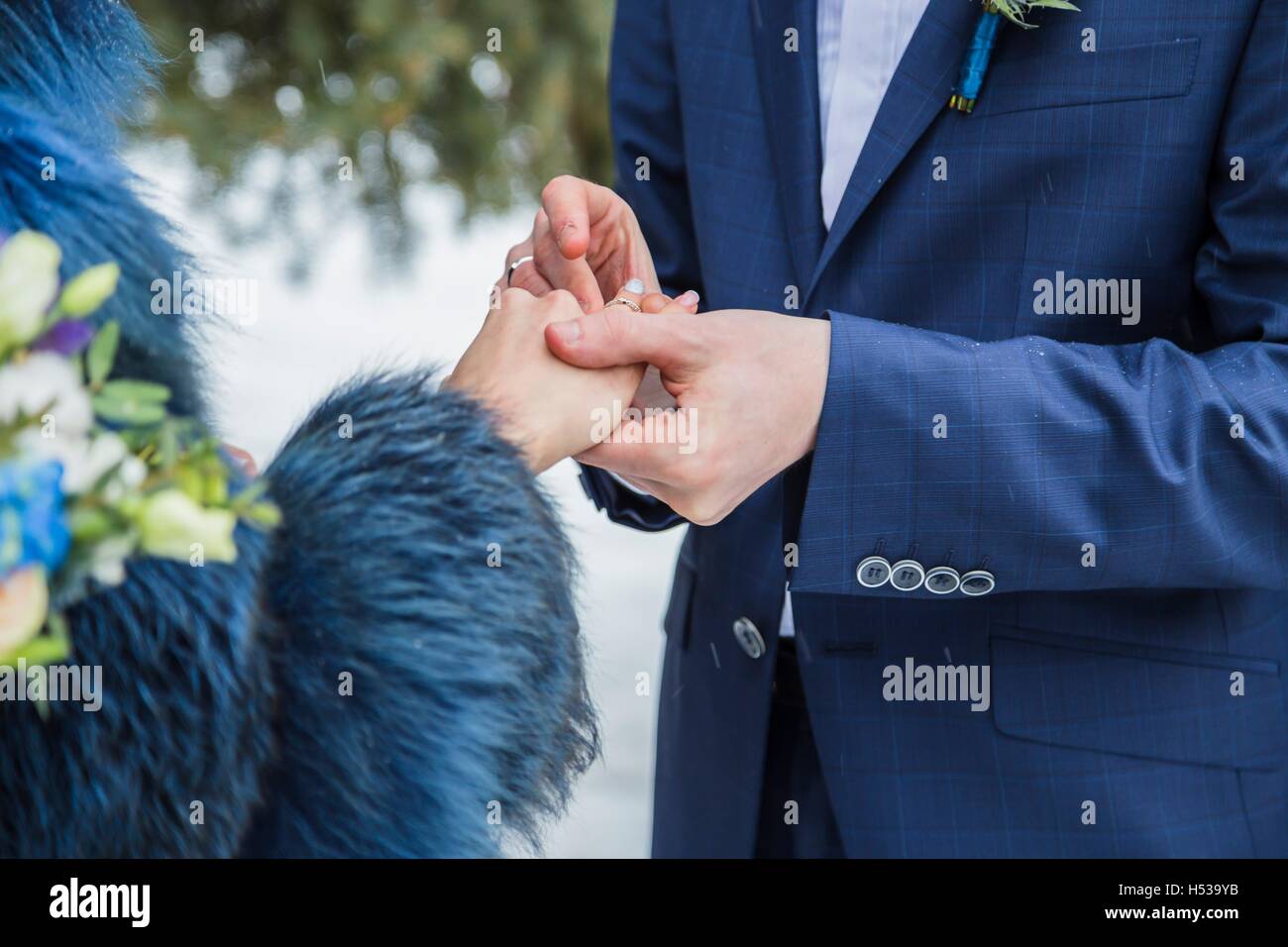 Close up groom put the wedding ring on bride Stock Photo