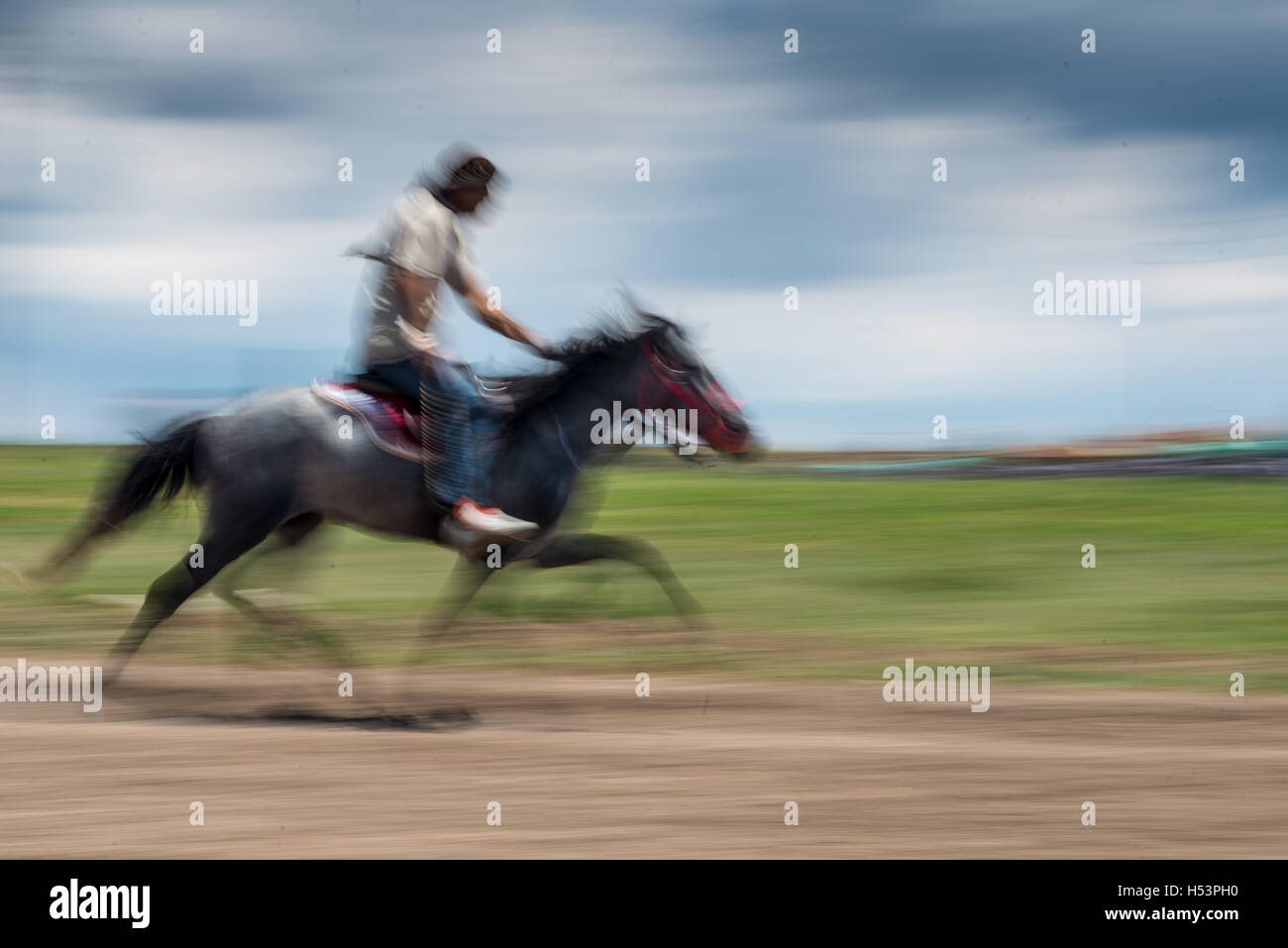 A motion blurred photo of horse riding. Stock Photo