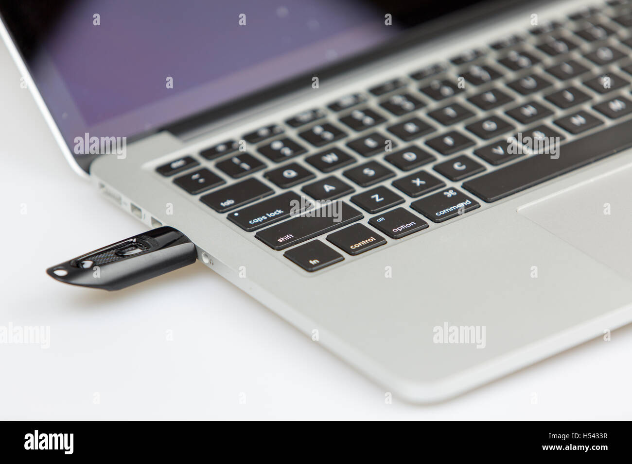 a black usb stick plugged on left side of laptop. closeup shot with focus  on keyboard and usb stick Stock Photo - Alamy
