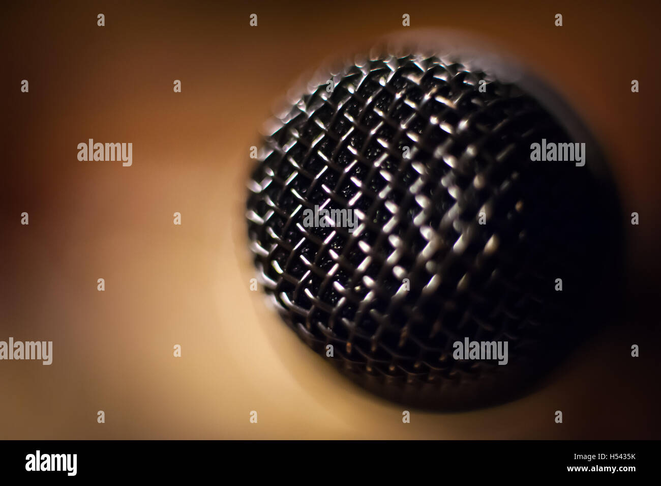 Microphone head extreme close up out of focus stage lights in background Stock Photo