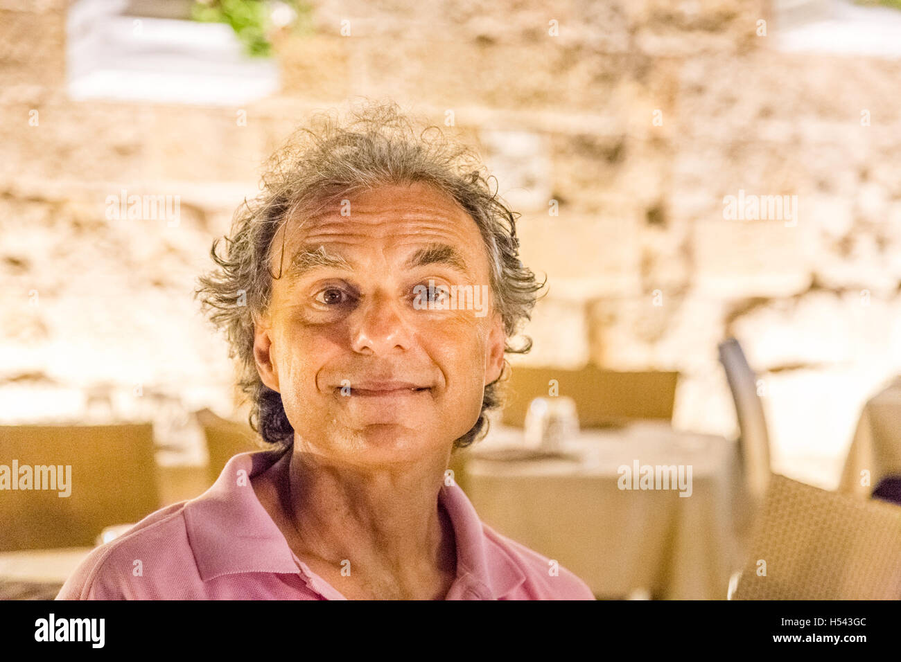 funny senior man making faces in a restaurant Stock Photo