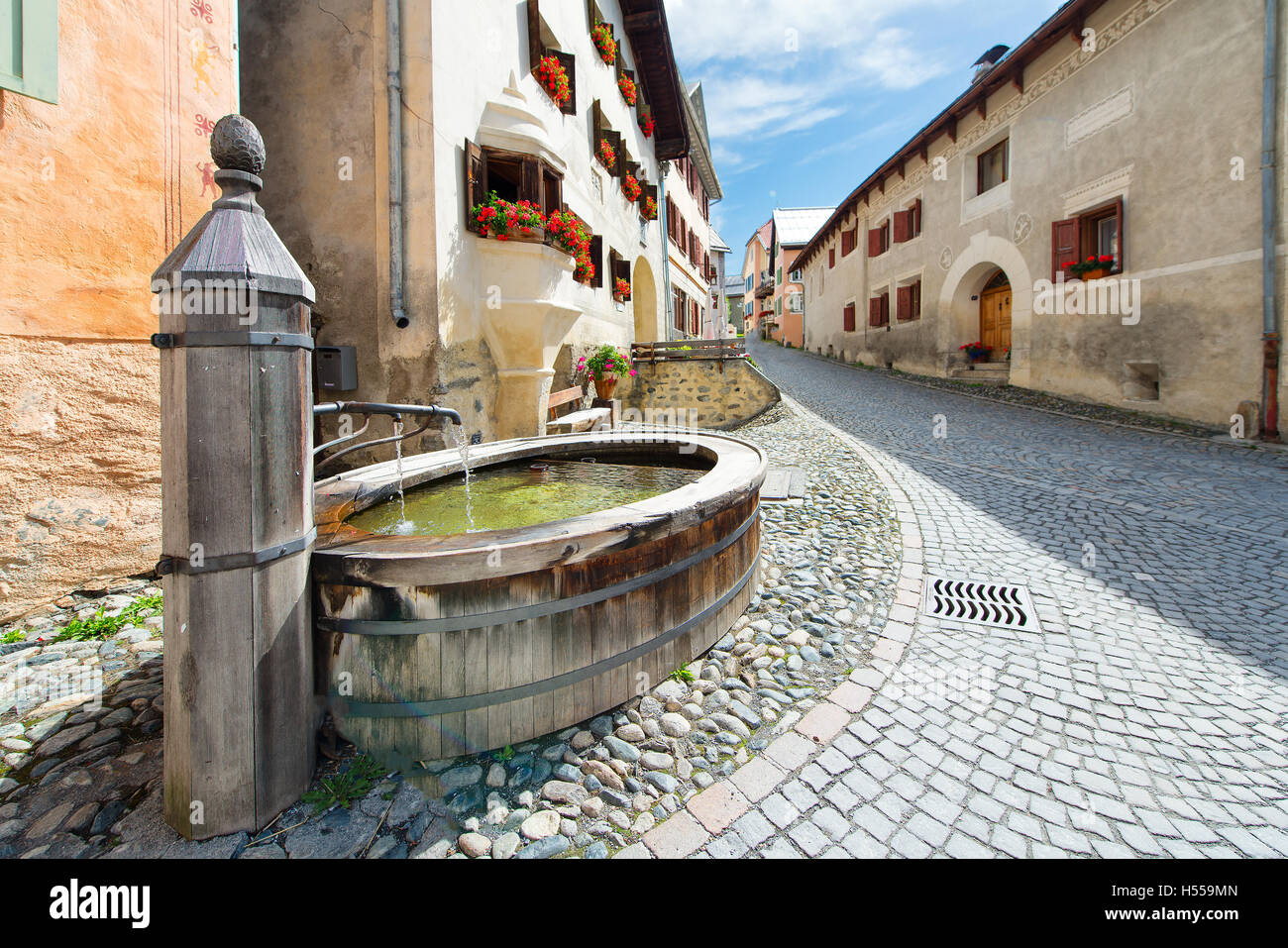 Old fountain in the Swiss Alpine village of Guarda in the Engadine valley i the aftermoon Stock Photo