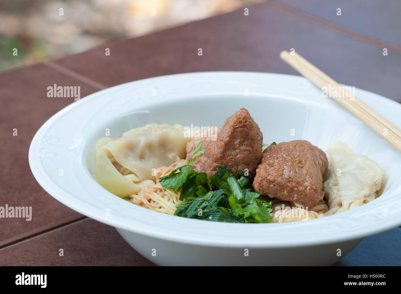 Egg noodle with delicious stewed pork and dumpling, closed up. Stock Photo