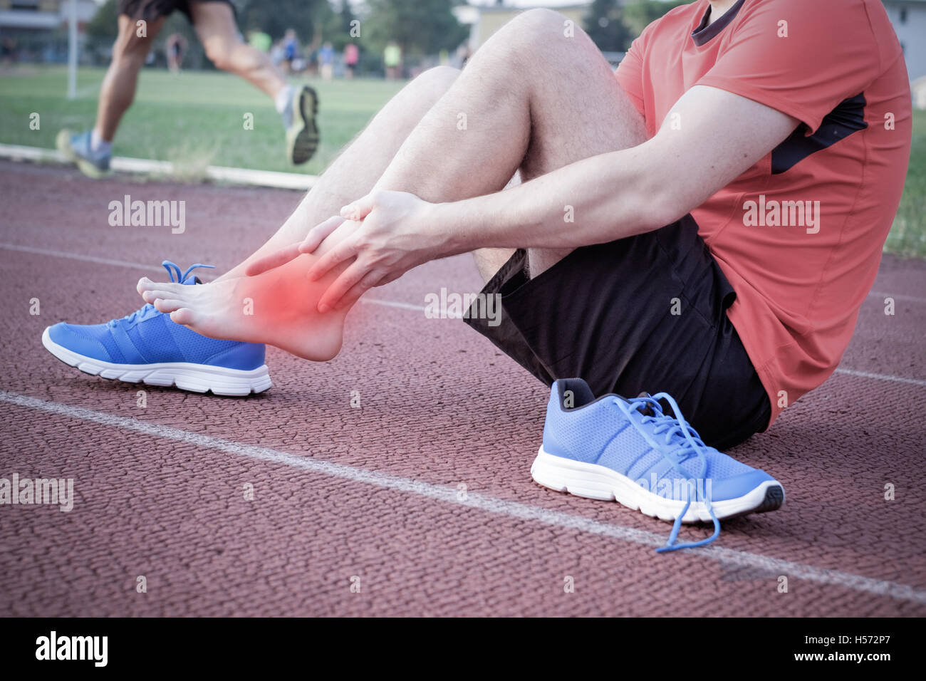 Runner with injured ankle on the track Stock Photo