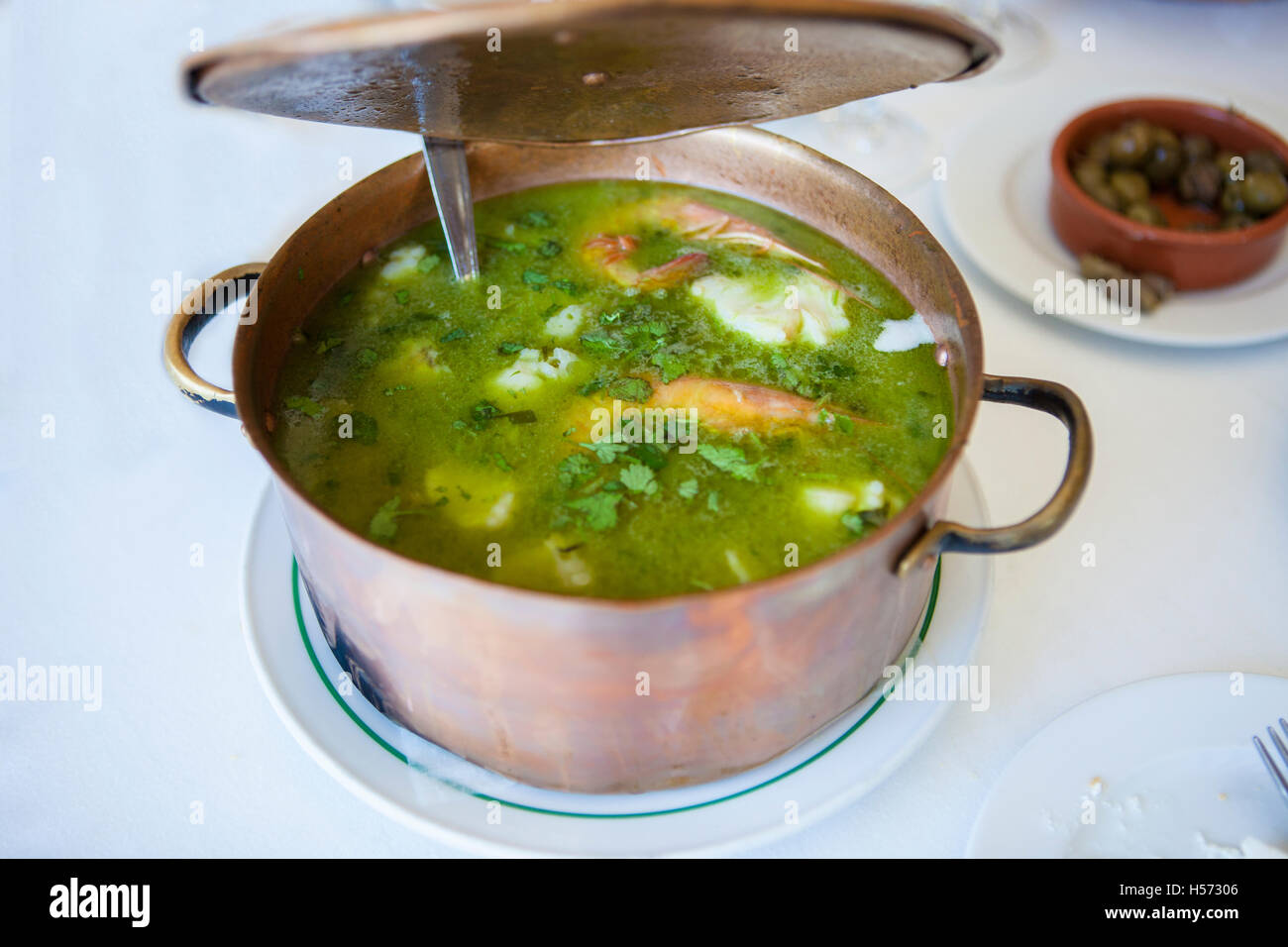 Arroz de Tamboril or soupy seafood rice, portuguese recipe. Opening casserole lid Stock Photo