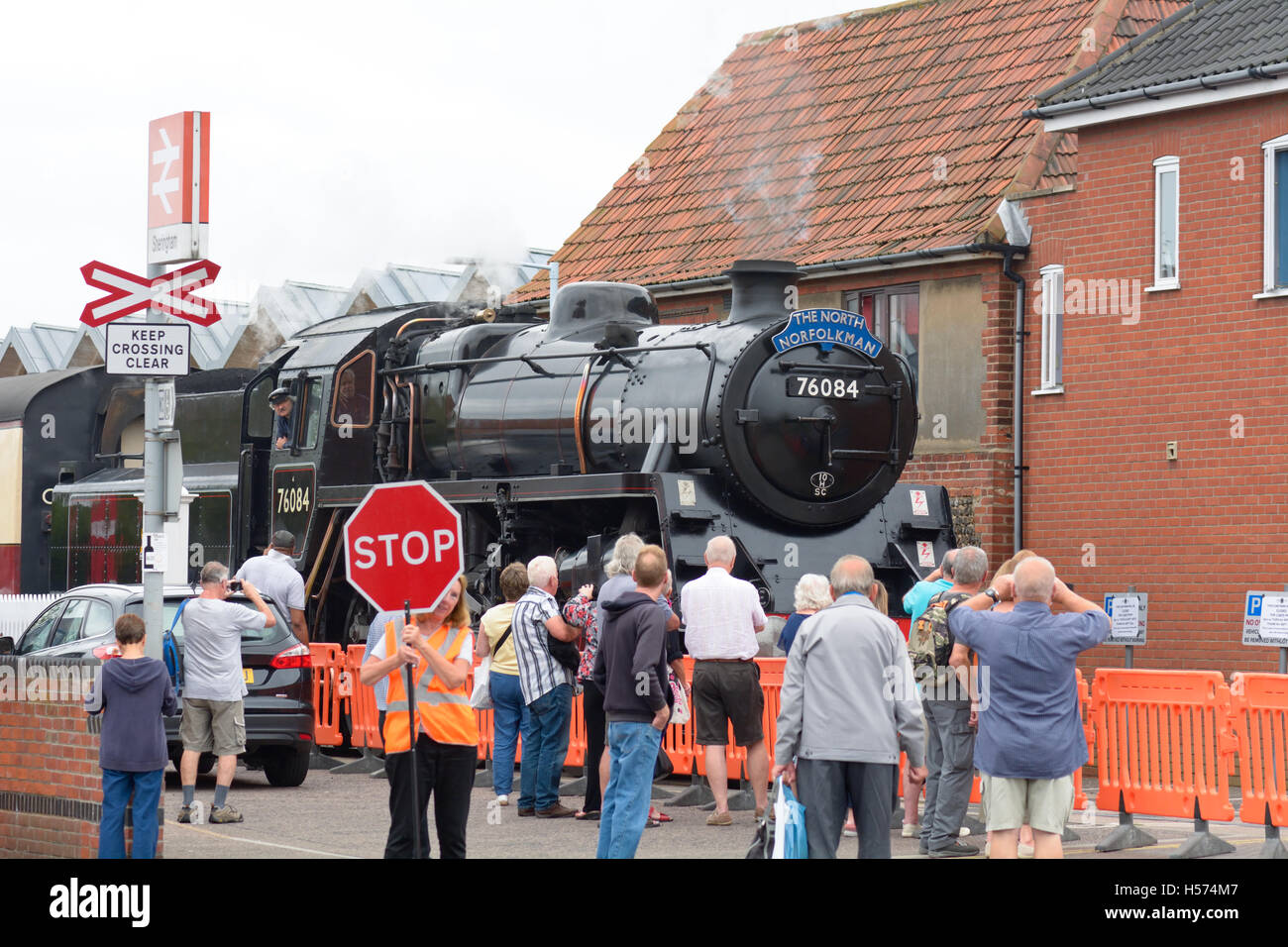 Rail enthusiasts watching The North Norfolkman steam train approaching Sheringham railway station, Norfolk, England Stock Photo