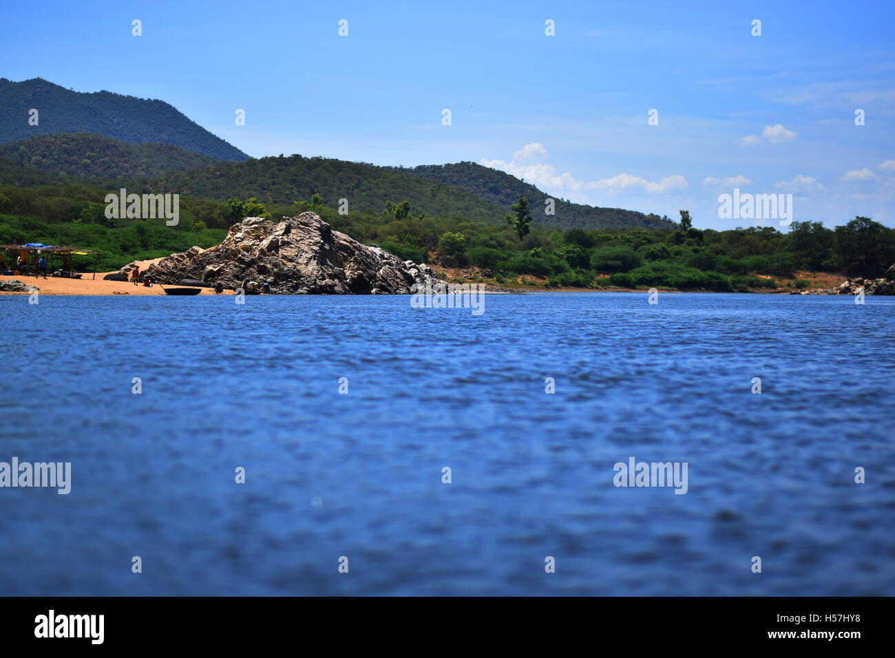 Blue fresh water lake surrounding forest and rocks Stock Photo