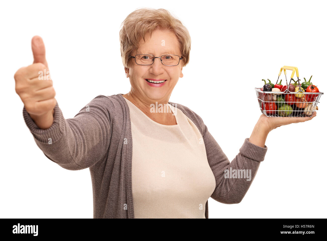 Mature woman holding a small shopping basket full of fruits and ...
