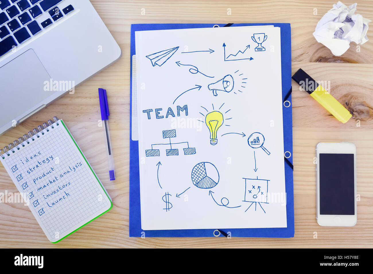 Top-view of desk with start-up sketches drawn on paper illustrating a new business project with diagrams and charts, laptop Stock Photo