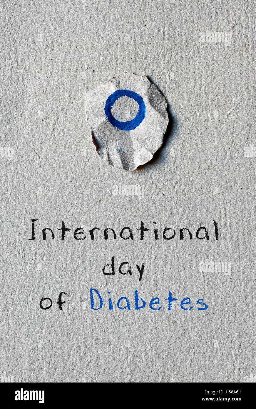 a blue circle, symbol of diabetes, painted in a round piece of paper