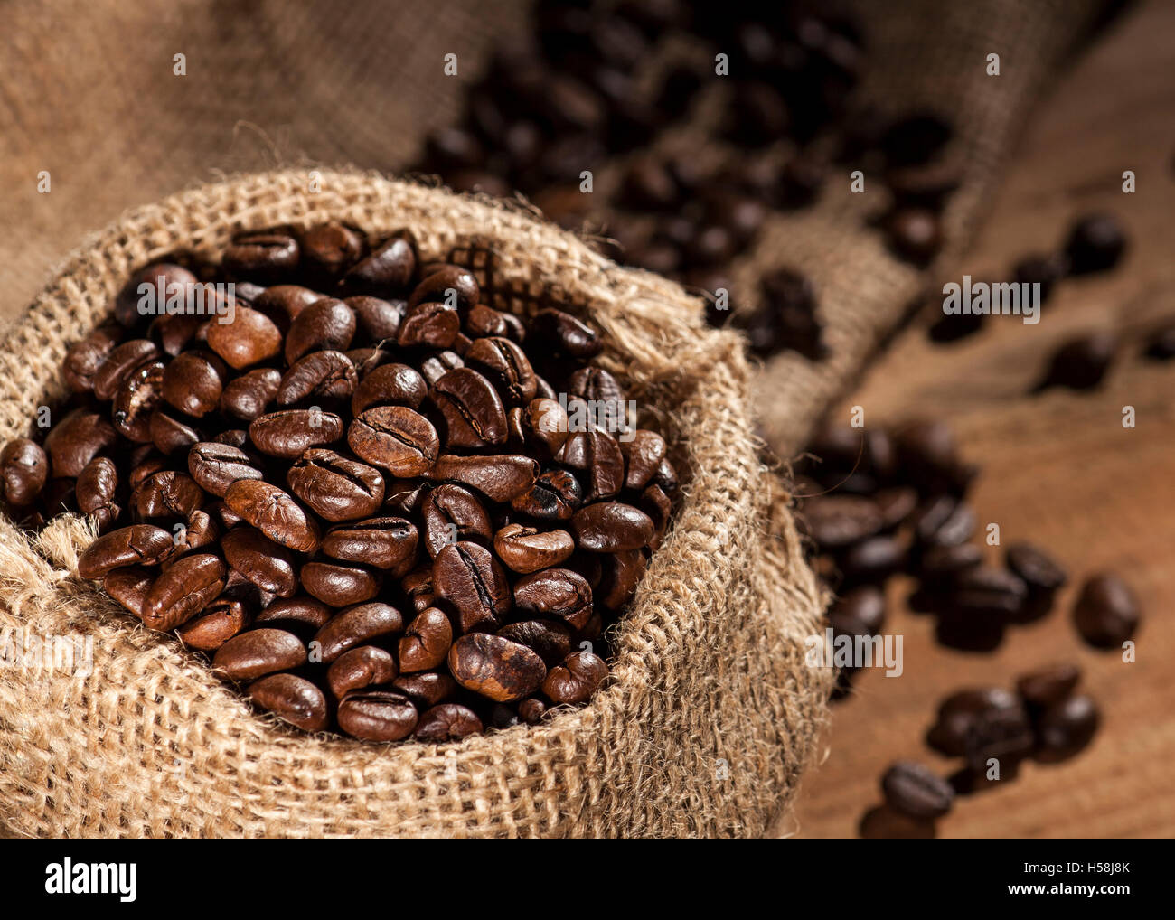 Sack with coffee beans on a wooden background Stock Photo - Alamy