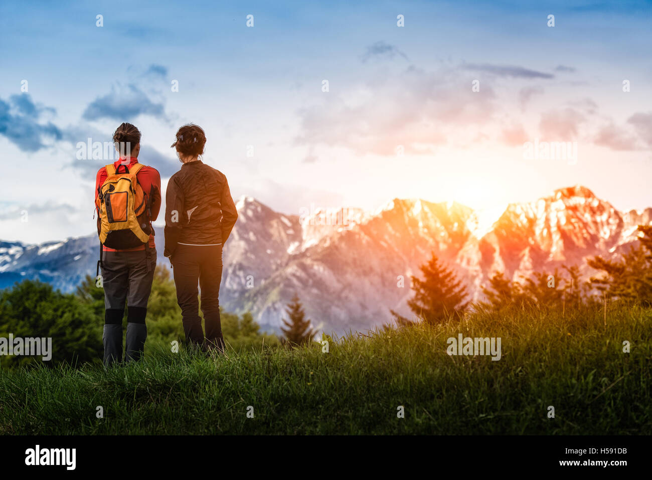 two girls look at the mountains while hiking Stock Photo - Alamy