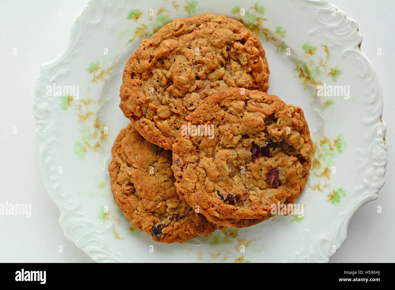 Fresh baked oatmeal raisin walnut cookies on pretty vintage plate from overhead in horizontal format Stock Photo