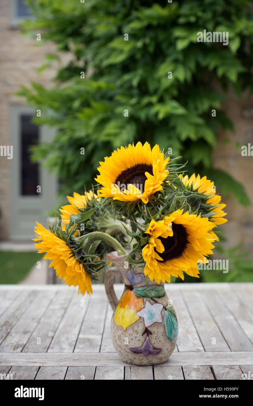 A vase of sunflowers on a garden table Stock Photo - Alamy