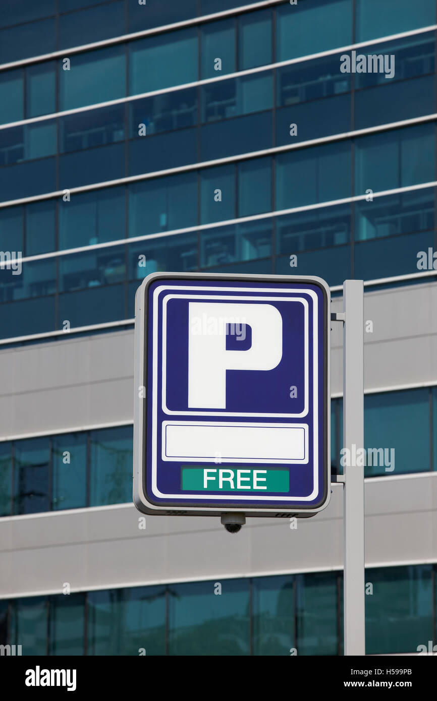 Parking signpost with free text and modern building background. Vertical Stock Photo