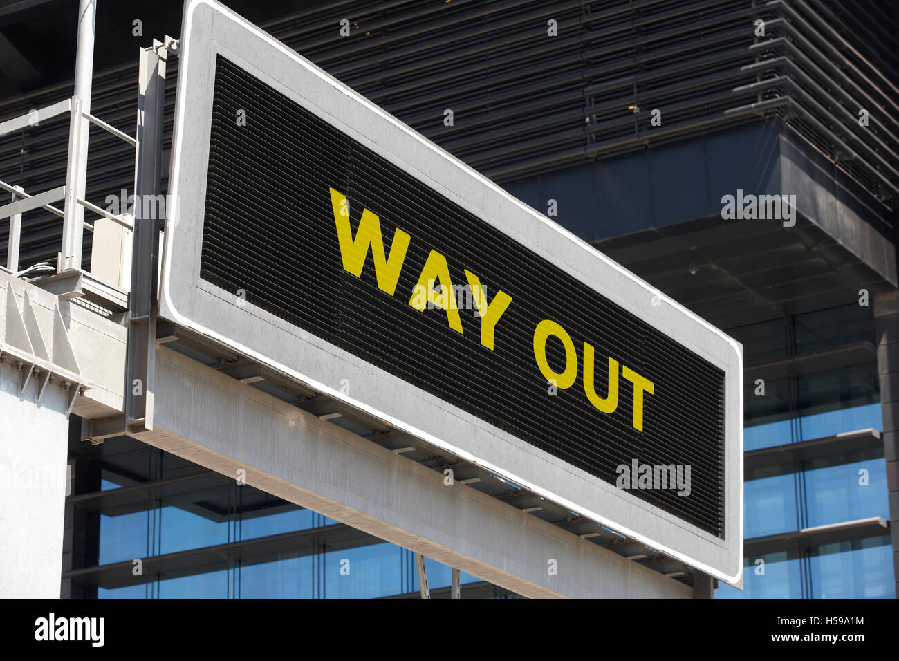 Way out signpost in the city with building facade background. Horizontal Stock Photo