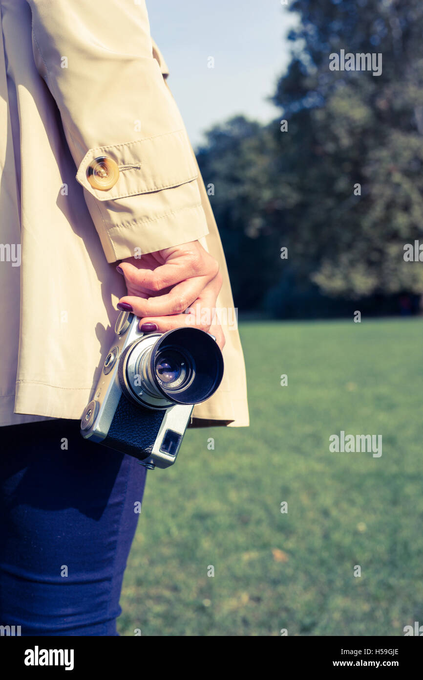 Young woman holding old camera in her hand Stock Photo