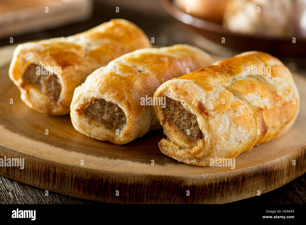 Delicious homemade sausage rolls on a wooden serving platter. Stock Photo