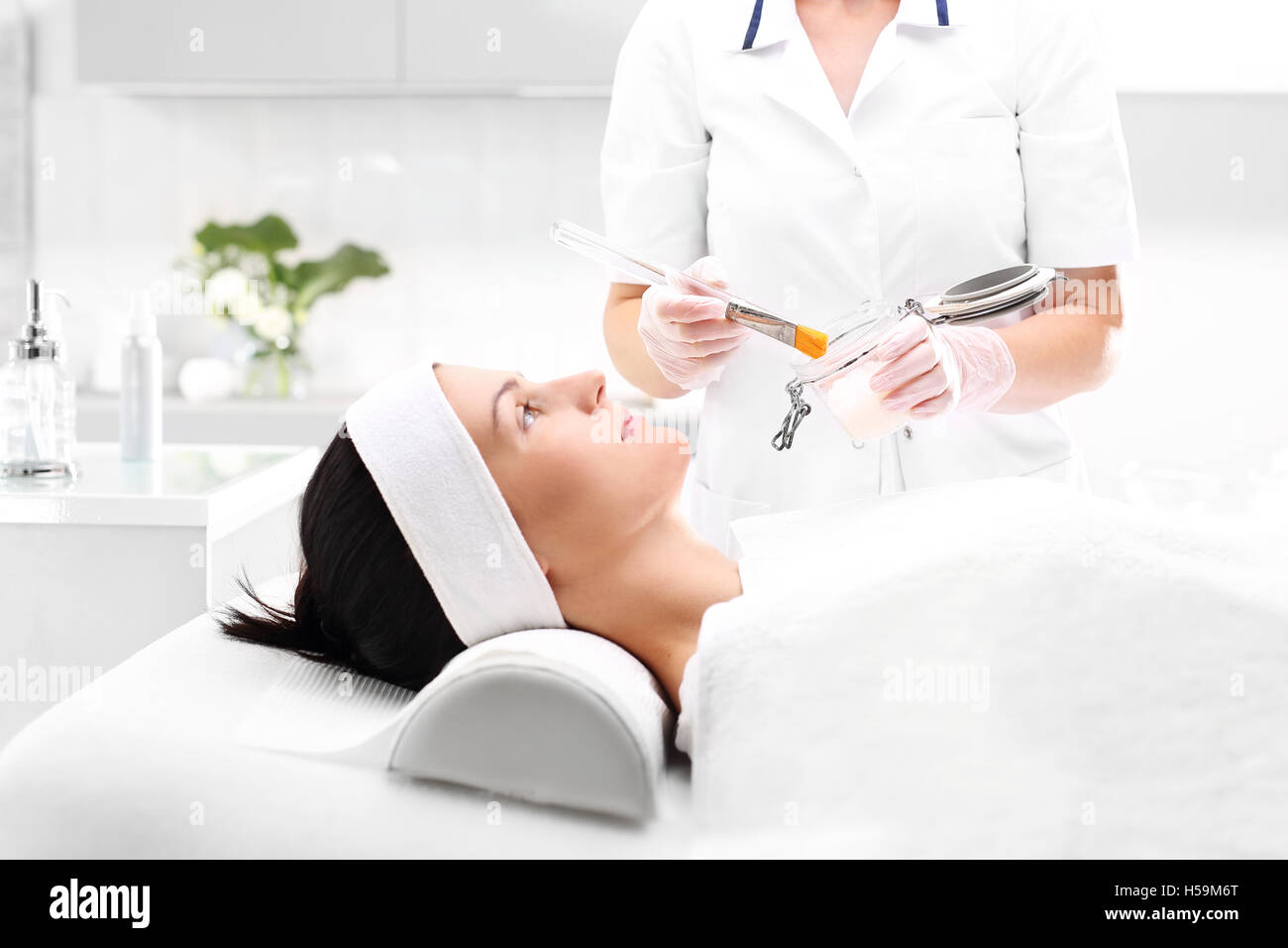 The woman in the beauty salon, beautician brush mask is applied to the neck Stock Photo