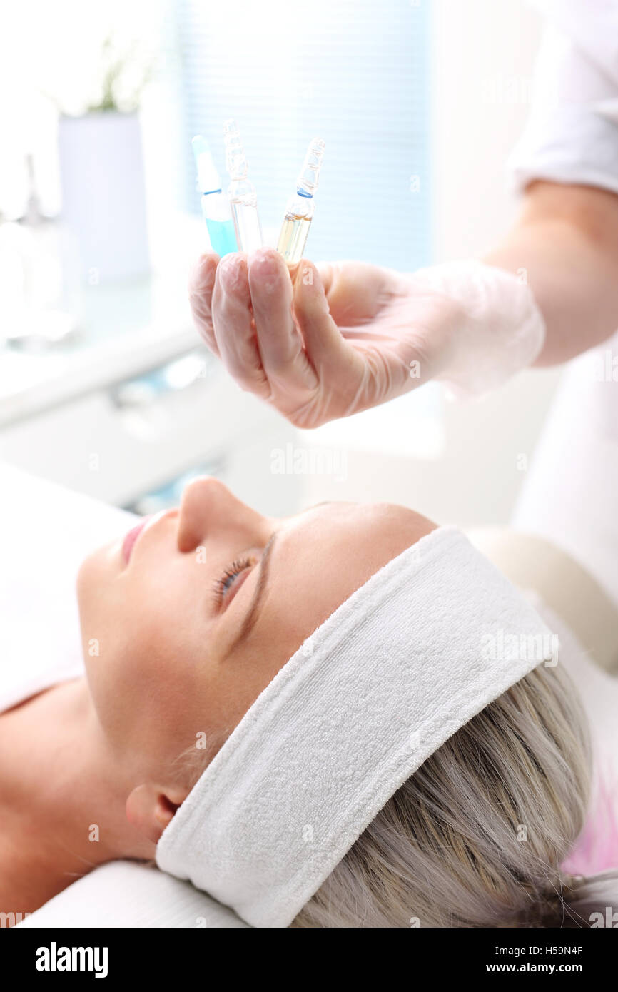 Cosmetic ampoule, serum applied to the face of a woman. Hand