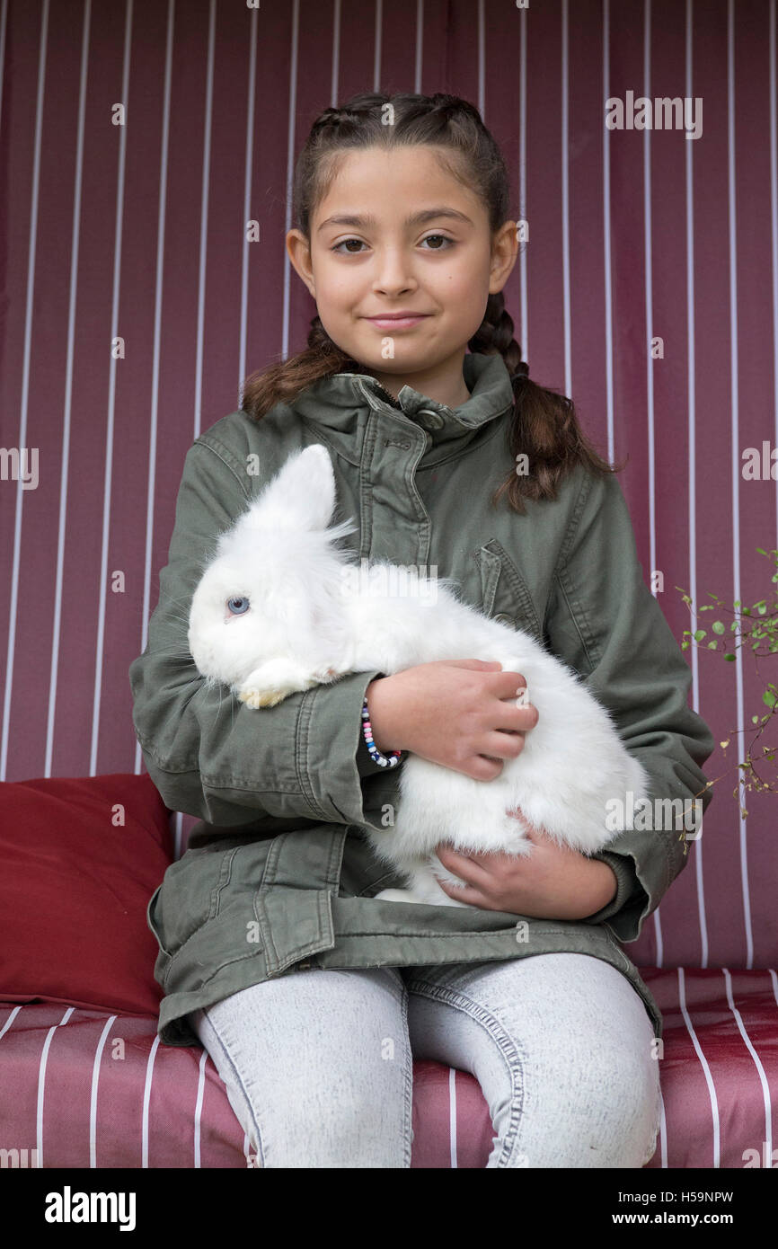 young girl caressing rabbit at children´s farm Kirchdorf, Hamburg ...