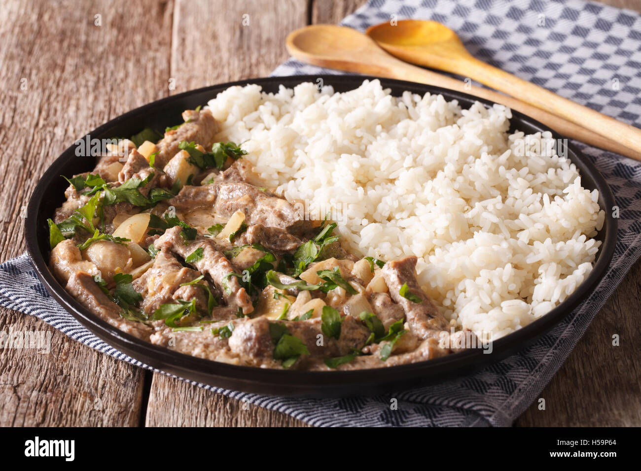 Russian cuisine: beef stroganoff with rice close-up on a plate on the table. horizontal Stock Photo
