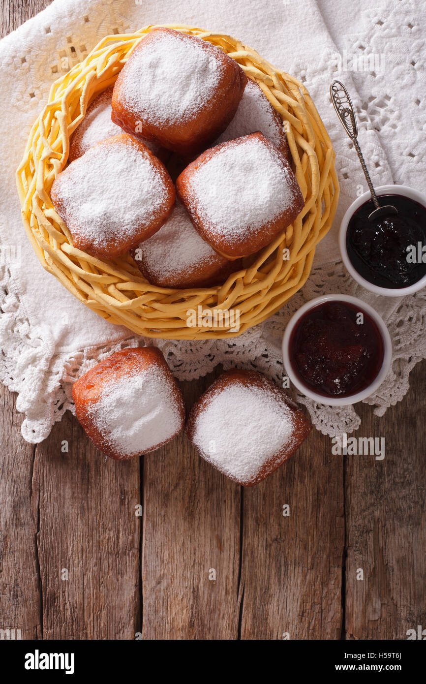 Sweet hot donuts with powdered sugar and jam on the table. vertical