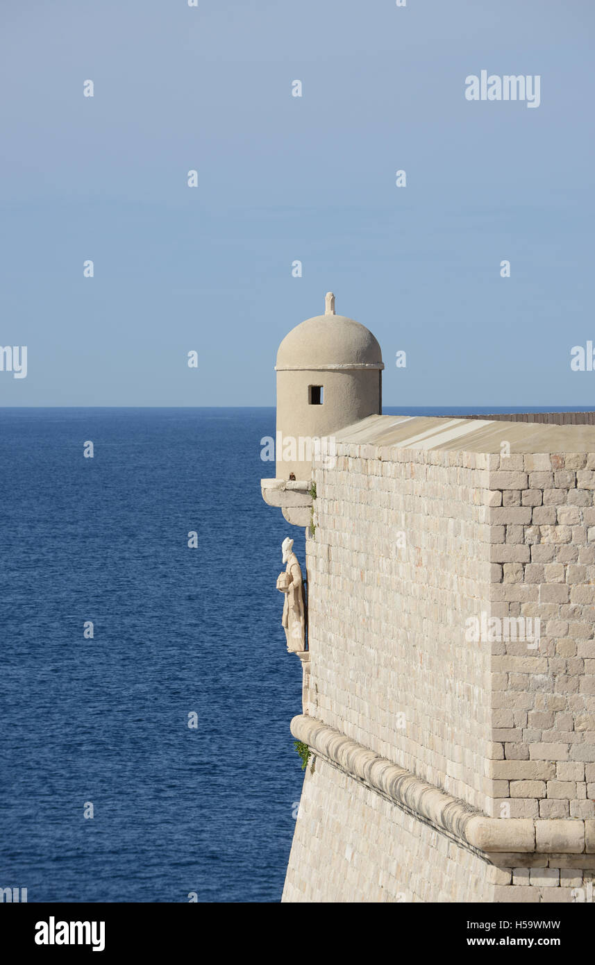 Stone wall and tower with St. Blaise statue overlooking sea, Croatia, Dubrovnik. Stock Photo