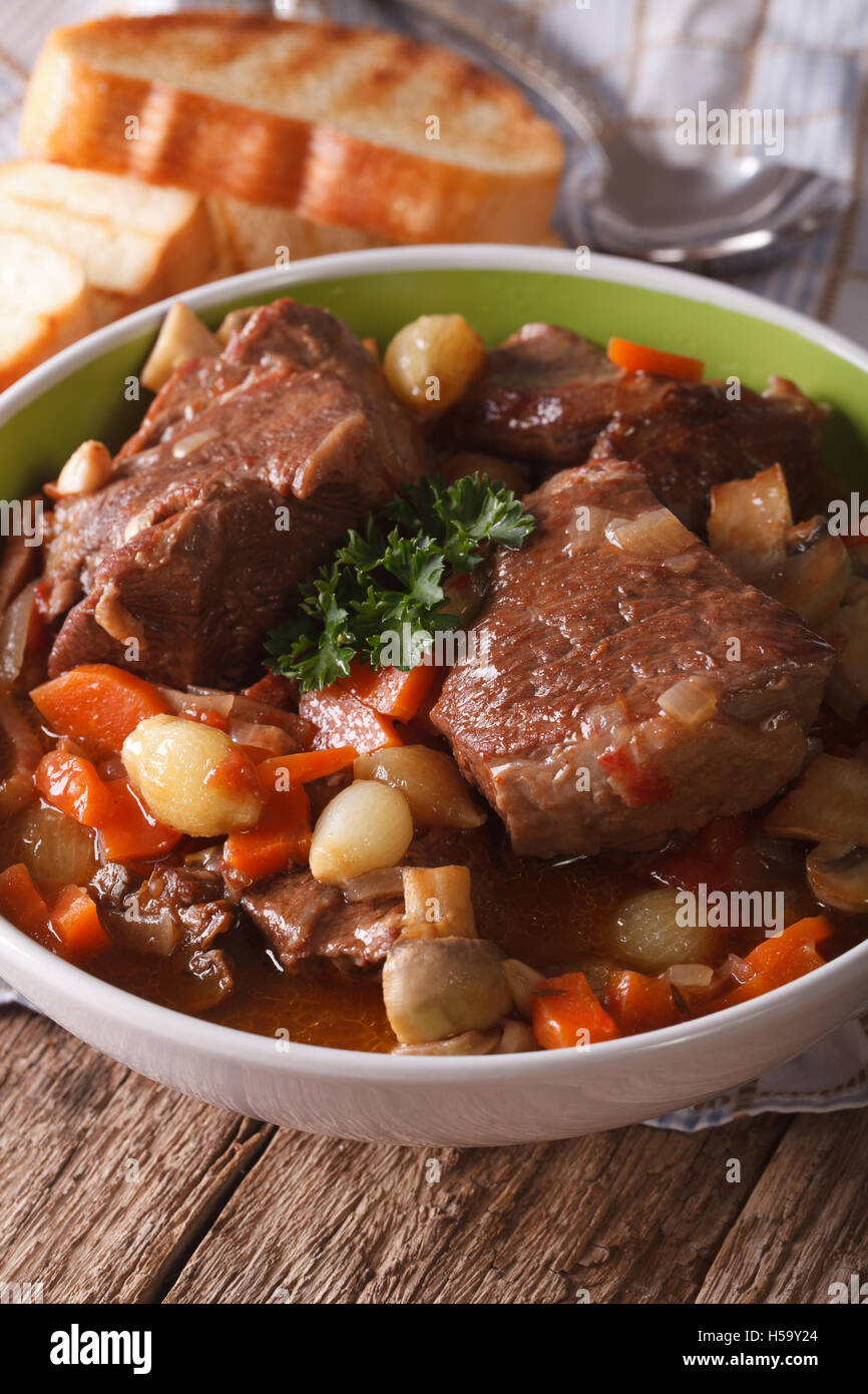 Beef Bourguignon with mushrooms close up in a bowl on the table. Vertical Stock Photo
