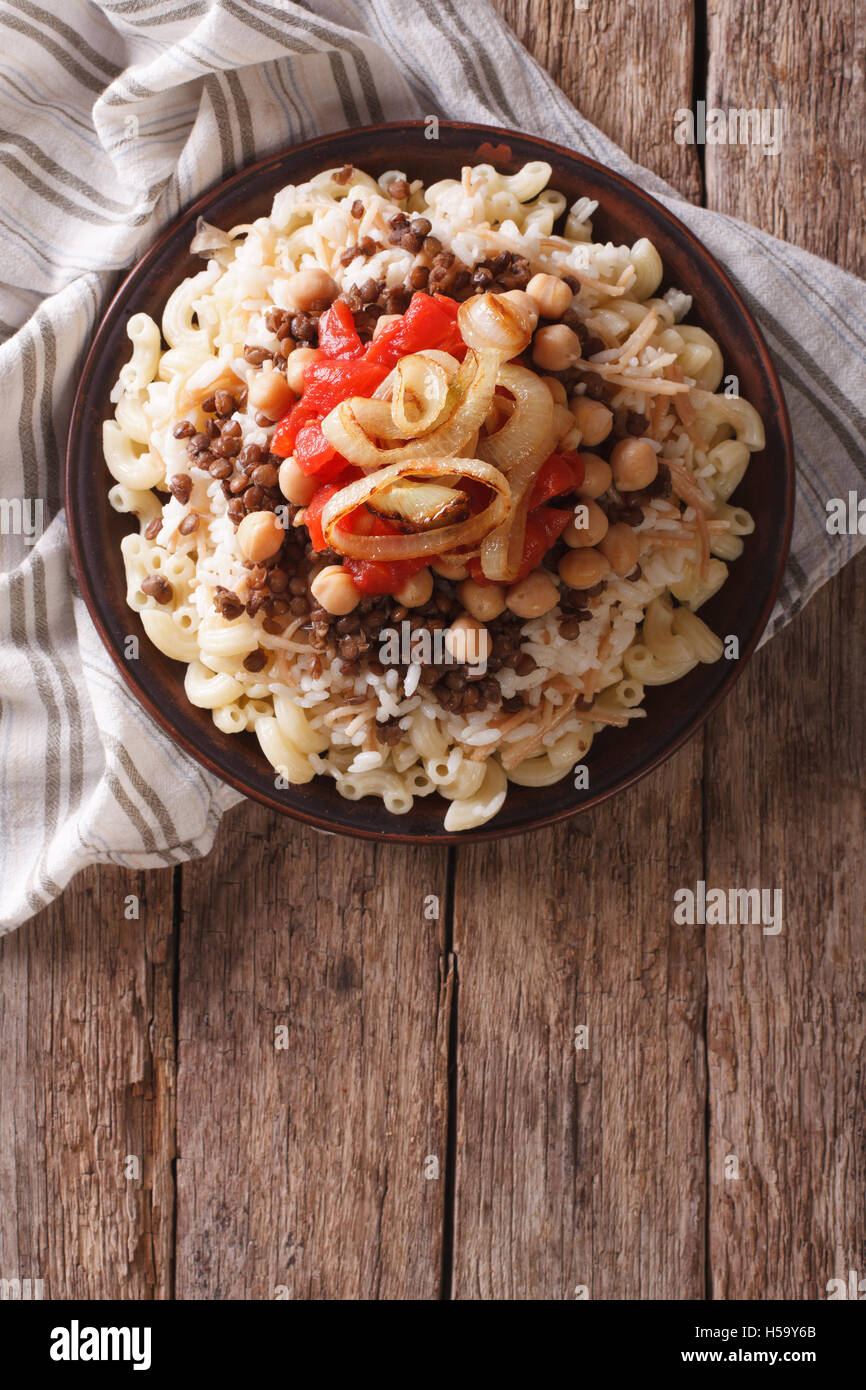 Arabic cuisine: kushari of rice, pasta, chickpeas and lentils on a plate Vertical top view Stock Photo