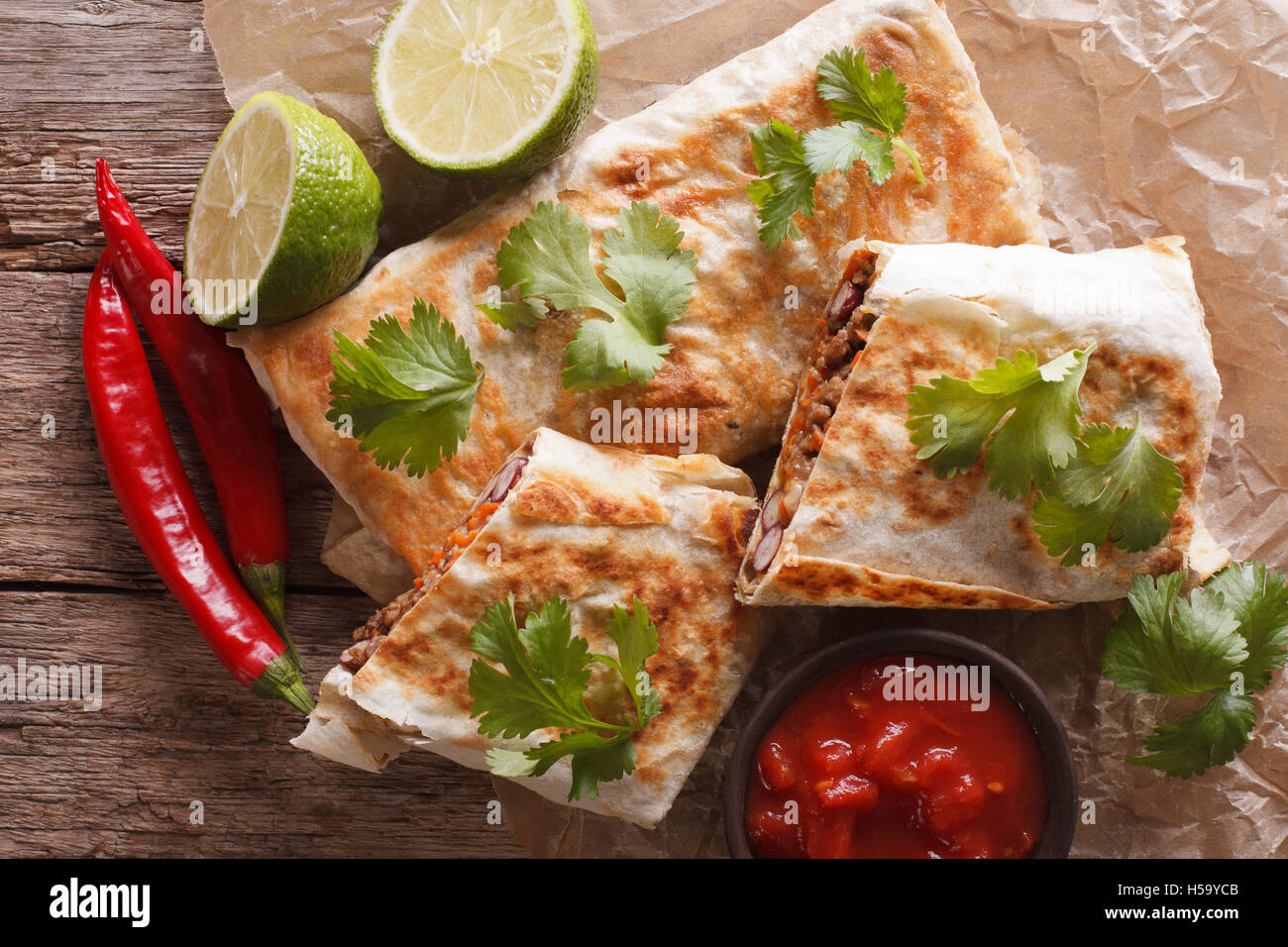 Mexican spicy chimichanga with meat and vegetables on the table close-up. horizontal view from above Stock Photo